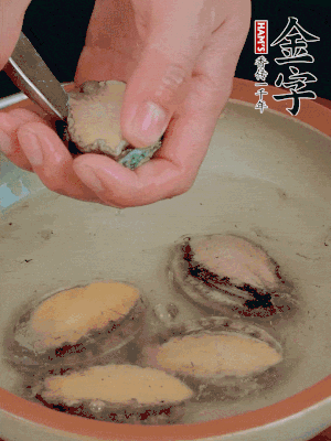 鮑魚加鹽、清水浸泡，用勺子挖出鮑魚肉。