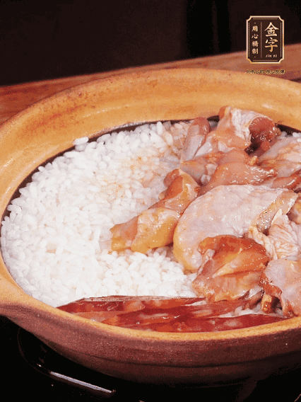 煮到椰子水微微收干轉(zhuǎn)小火，快速均勻鋪上雞肉、金字香腸